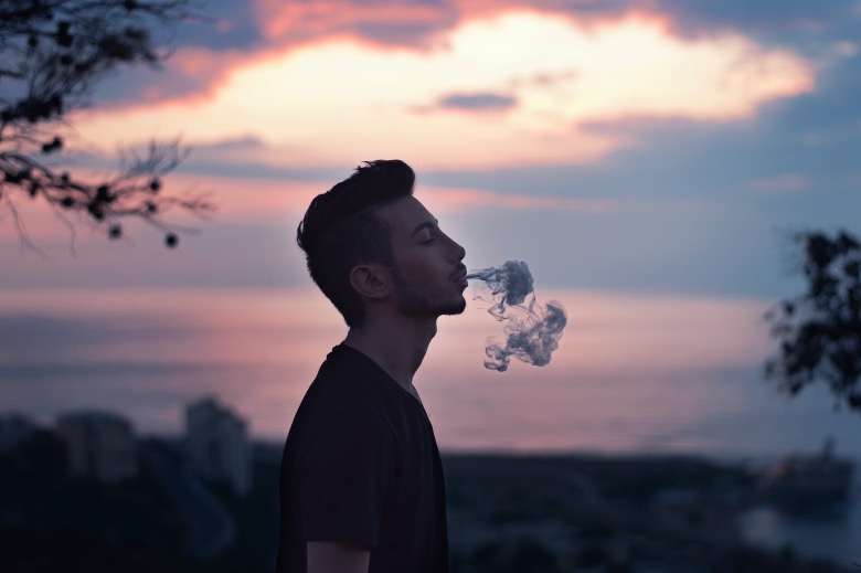 Ragazzo che fuma e-cig distante dai bambini