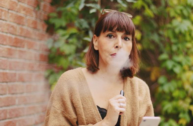 donna che utilizza una e-cigarette a guancia