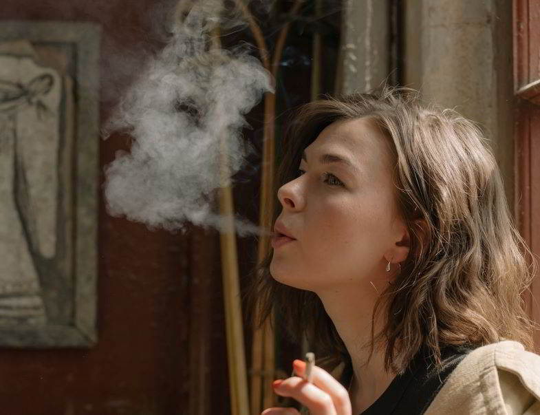 ragazza che fuma costretta a prenotare lo sbiancamento dentale