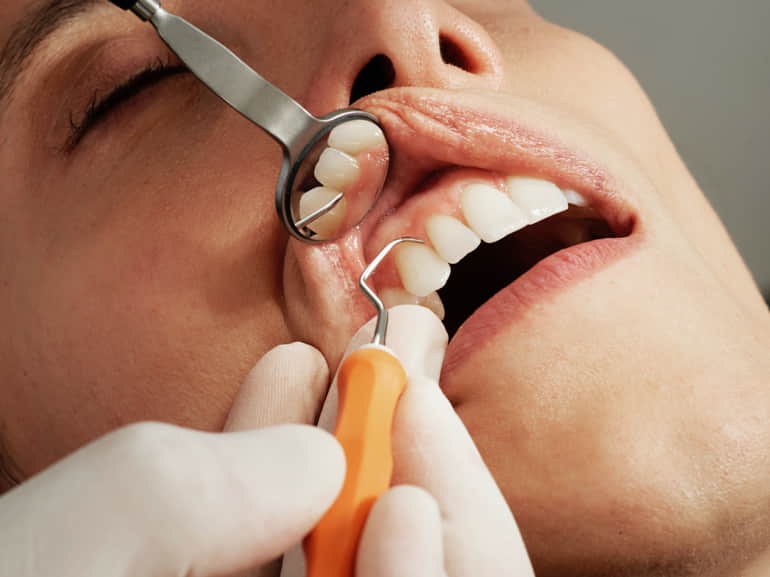 Dentista che esamina la salute orale di una paziente