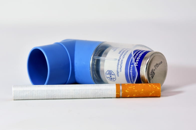 Inalatore per asmatici accanto a una sigaretta tradizionale