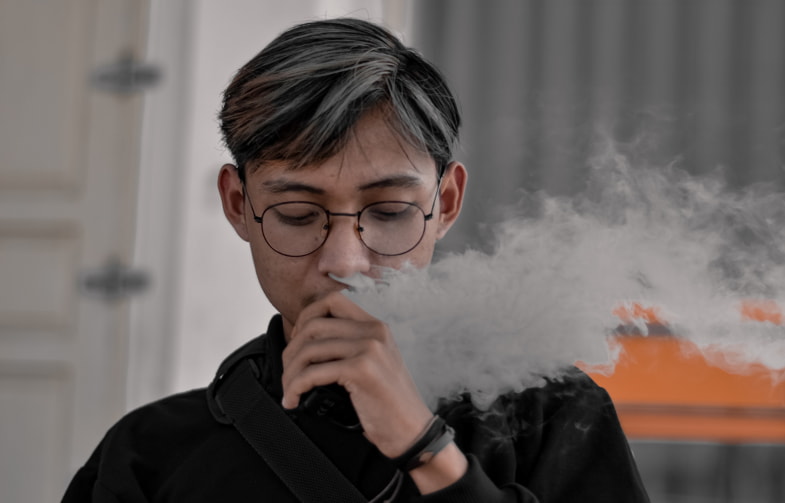 Ragazzo che svapa senza sentire il sapore dell'e-liquid